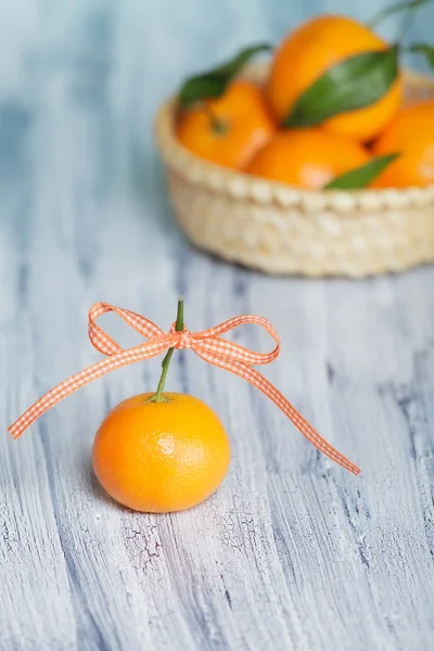 Renkli Bant mavi-beyaz eski tablo ile bir mandarin. diğer bir mandalina ile sepeti