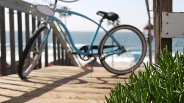 자전거 크루저 자전거는 캘리포니아 해안에 있는 바 다 해변에 있습니다. 여름의 주기, 계단, 야자나무. — 비디오