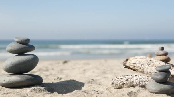 Ροκ ισορροπία στην παραλία του ωκεανού, πέτρες στοίβα από κύματα θαλασσινού νερού. Πυραμίδα από βότσαλα, φασκόμηλο. — Αρχείο Βίντεο