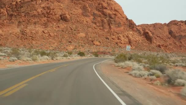 Road trip, körning auto i Valley of Fire, Las Vegas, Nevada, USA. Liftar i Amerika, åker landsväg. Röd utomjordisk stenformation, Mojaveöknen ser ut som Mars. Utsikt från bilen — Stockvideo
