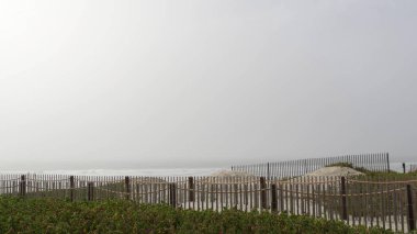 Tahta çit, kumlu plaj, California USA. Pasifik Okyanusu kıyıları, denizin sisi....