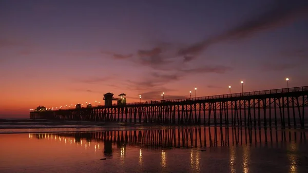 Pier silueta Oceanside California USA. Tropická pláž přílivu a odlivu. Letní pochmurná atmosféra. — Stock fotografie
