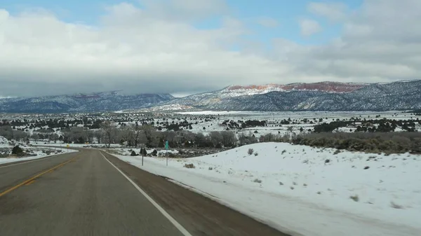 Road trip aux États-Unis de Zion à Bryce Canyon, en voiture dans l'Utah. Voyage en auto-stop en Amérique, Route 89 vers la forêt de Dixie. Voyage local d'hiver, atmosphère calme et montagnes de neige. Vue de la voiture — Photo