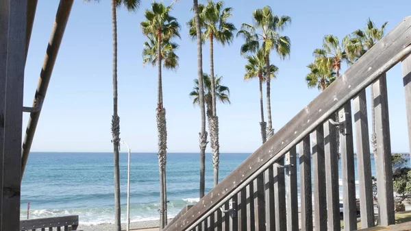 Wooden stairs, beach access in California USA. Coastal stairway, pacific ocean waves and palm trees. — Stock Photo, Image