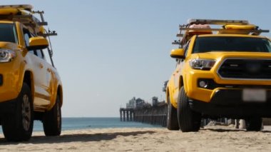 Sarı cankurtaran arabası, Oceanside Sahili, Kaliforniya ABD. Kurtarma aracı, cankurtaran kamyonu, cankurtaranlar aracı. İkonik otomobil ve okyanus kıyısı. Los Angeles titreşimleri, yaz dönemi estetik atmosferi.