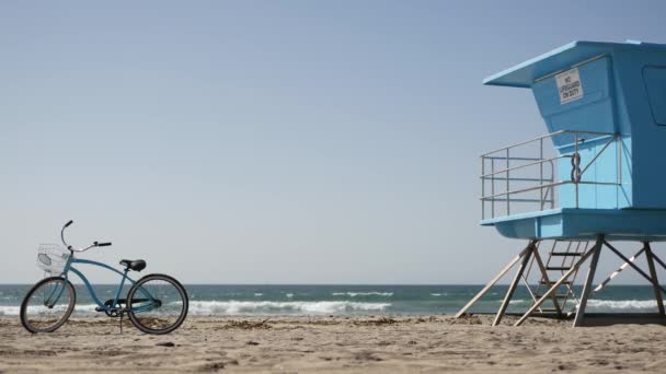 Велосипед велосипеда на березі океану Каліфорнійського узбережжя США. Літній морський берег. Велосипед рятувальною вежею — стокове відео