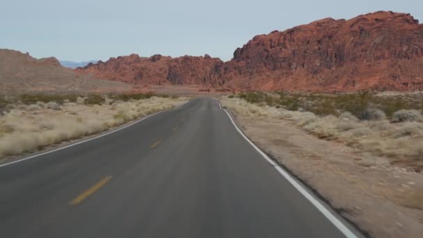 Viaje por carretera, conducción de automóviles en Valley of Fire, Las Vegas, Nevada, EE.UU.. Autoestop viajando por América, viaje por carretera. Formación de rocas alienígenas rojas, desierto de Mojave se parece a Marte. Vista desde el coche — Vídeos de Stock