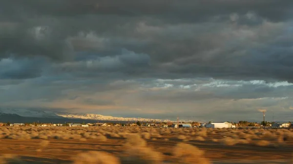Viaje por carretera, conduciendo auto desde Death Valley a Las Vegas, Nevada, EE.UU. Hacer autostop viajando por América. Viaje por carretera, atmósfera dramática, montaña al atardecer y desierto de Mojave. Vista desde el coche — Foto de Stock
