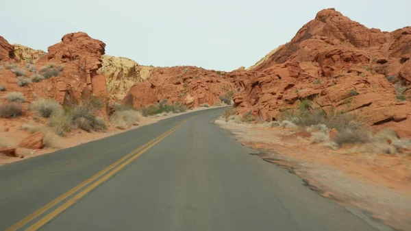 ロードトリップ,火災の谷で自動車を運転,ラスベガス,ネバダ州,アメリカ.アメリカでのヒッチハイキング、高速道路の旅。赤い異星人の岩の形成、モハーヴェ砂漠の荒野は、火星のように見えます。車からの眺め — ストック写真