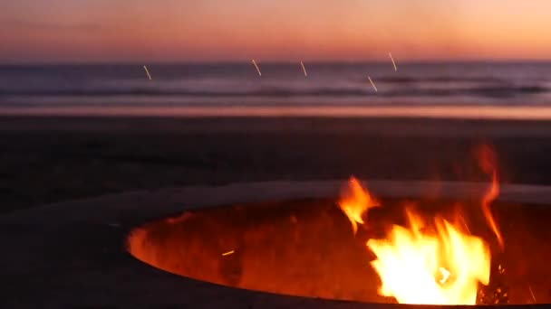 Hoyo de fogata en California USA. Fuego de campamento en la playa del océano crepúsculo, llama de hoguera por las olas de agua de mar. — Vídeos de Stock