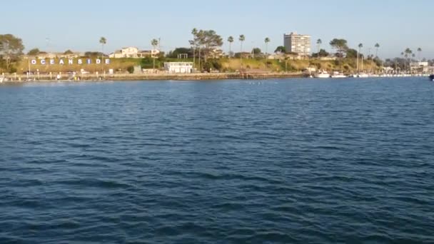 Vista sul tramonto dell'acqua di mare da barca a vela o yacht, porto Oceanside, vacanze estive in California USA. Segnaletica in porto, lettere di testo nel porto turistico. Oceano Pacifico, tour di avvistamento balene. — Video Stock