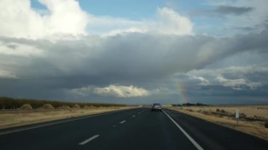 Araba kullanmak, California, ABD 'de araba gezisi, arabadan manzara. Otostop çekerek Amerika 'ya gitmek. Otoyol, dağlar ve yağmur fırtınasından önce bulutlu dramatik gökyüzü. Amerikan manzaralı yol. Yolcu POV