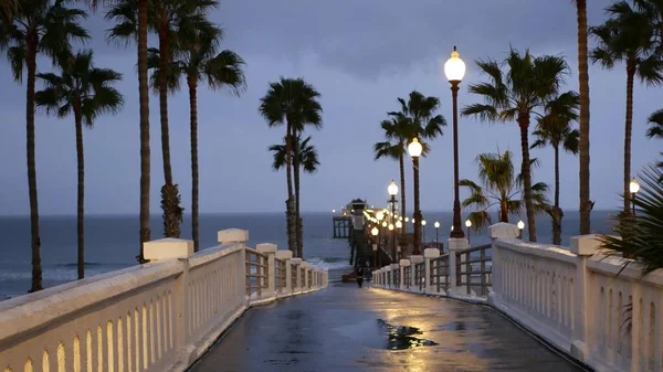 Krople deszczu, wieczorem w Oceanside California USA. Molo, dłonie o zmierzchu. Odbicie światła. — Zdjęcie stockowe