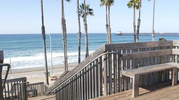 Wooden stairs, beach access in California USA. Coastal stairway, pacific ocean waves and palm trees. — Stock Photo, Image