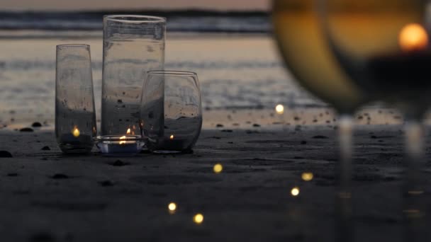 Candle flame lights in glass, romantic beach date by ocean waves, summer sea. Candlelight on sand. — Stock Video