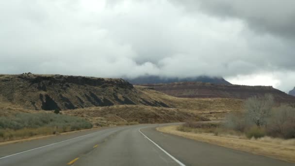 Road trip, driving auto in Zion Canyon, Utah, USA. Hitchhiking traveling in America, autumn journey. Red alien steep cliffs, rain and bare trees. Foggy weather and calm fall atmosphere. View from car — Stock Video