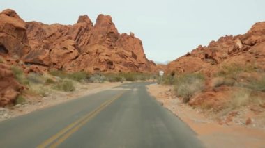 Araba gezisi, Ateş Vadisi, Las Vegas, Nevada, ABD. Amerika 'da otostop çekmek, otoban yolculuğu. Kızıl uzaylı kaya oluşumu, Mojave çölü vahşi doğası Mars 'a benziyor. Arabadan görüntüle