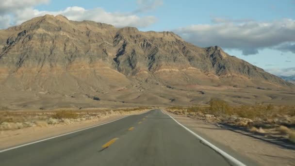 Perjalanan, mengemudi mobil dari Death Valley ke Las Vegas, Nevada USA. Menumpang perjalanan di Amerika. Jalan raya perjalanan, suasana dramatis, awan, gunung dan gurun Mojave. Tampilan dari mobil — Stok Video