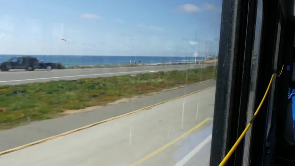 Окно автобуса, тихоокеанское побережье, автострада 101, Калифорния, США. Дорожное путешествие вдоль летнего океана или моря. — стоковое фото