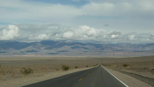 Ölüm Vadisi 'ne yolculuk, California, ABD' de araba kullanmak. Amerika 'da otostop çekmek. Otoyol, dağlar ve kuru çöl, kurak iklim yabanı. Arabadan yolcu arabası. Nevada 'ya yolculuk — Stok fotoğraf