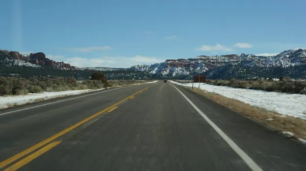 Roadtrip in den USA von Zion zum Bryce Canyon, Autofahren in Utah. Per Anhalter durch Amerika, Route 89 nach Dixie Forest. Winterreise, ruhige Atmosphäre und Schneeberge. Blick aus dem Auto — Stockfoto