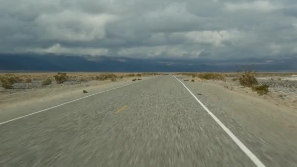 Road trip to Death Valley, driving auto in California, USA. Hitchhiking traveling in America. Highway, mountains and dry desert, arid climate wilderness. Passenger POV from car. Journey to Nevada — Stock Video