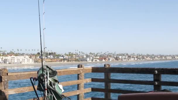 Pesca d'acqua salata sul molo, attrezzatura da pesca o attrezzi. California USA. Acqua, canna o filatura dell'oceano marino. — Video Stock