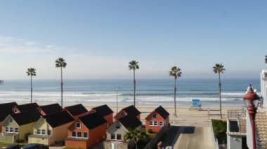 Oceanside California USA 'deki kulübeler. Deniz kenarındaki bungalovlar. Okyanus sahili palmiyeleri. Cankurtaran kulesi.
