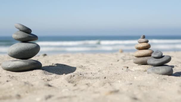 岩石在海滩上保持平衡,石头被海浪堆积在一起.沙质海岸上的卵石金字塔 — 图库视频影像