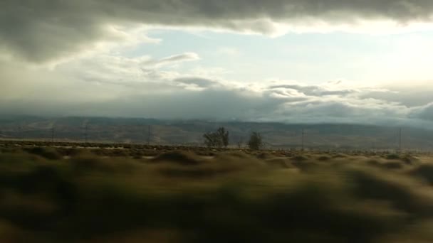 Autofahren, Roadtrip in Kalifornien, USA, Blick aus dem Auto. Per Anhalter durch die Vereinigten Staaten. Autobahn, Berge und wolkenverhangener Himmel vor Regensturm. Amerikanische Landschaften. Passagierflugzeug — Stockvideo