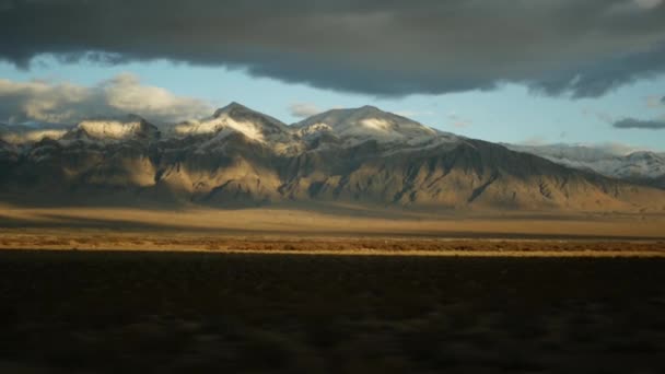 Perjalanan, mengemudi mobil dari Death Valley ke Las Vegas, Nevada USA. Menumpang perjalanan di Amerika. Jalan raya perjalanan, suasana dramatis, matahari terbenam gunung dan gurun gurun Mojave. Tampilan dari mobil — Stok Video