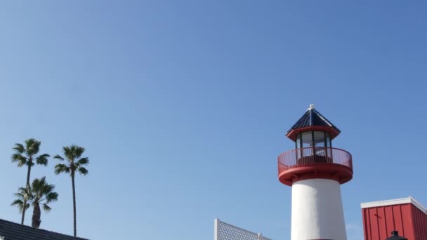 Lighthouse, palm trees and blue sky. Red and white beacon. Waterfront harbor village. California USA — Stock Video