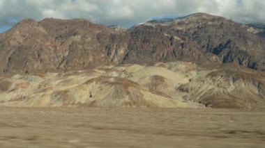 Ölüm Vadisi 'ne yolculuk, Artists Palette Drive, California USA. Otostop çekerek Amerika 'ya gitmek. Otoyol, renkli çıplak dağlar ve kurak iklim yabanı. Arabadan görüntü. Nevada 'ya yolculuk