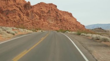 Araba gezisi, Ateş Vadisi, Las Vegas, Nevada, ABD. Amerika 'da otostop çekmek, otoban yolculuğu. Kızıl uzaylı kaya oluşumu, Mojave çölü vahşi doğası Mars 'a benziyor. Arabadan görüntüle