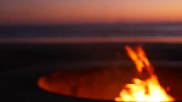 Hoyo de fogata en California USA. Fuego de campamento en la playa del océano crepúsculo, llama de hoguera por las olas de agua de mar. — Vídeos de Stock