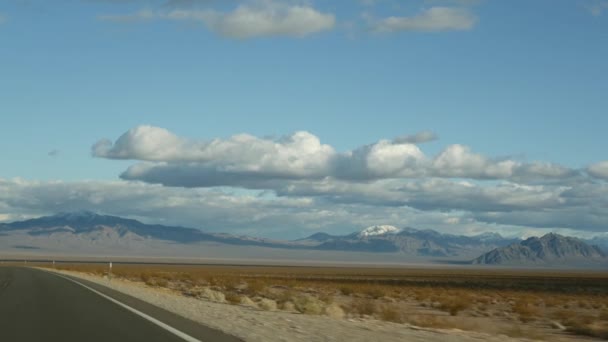 Road trip, auto rijden van Death Valley naar Las Vegas, Nevada USA. Liften op reis in Amerika. Highway reis, dramatische sfeer, wolk, berg en Mojave woestijn wildernis. Zicht vanuit auto — Stockvideo