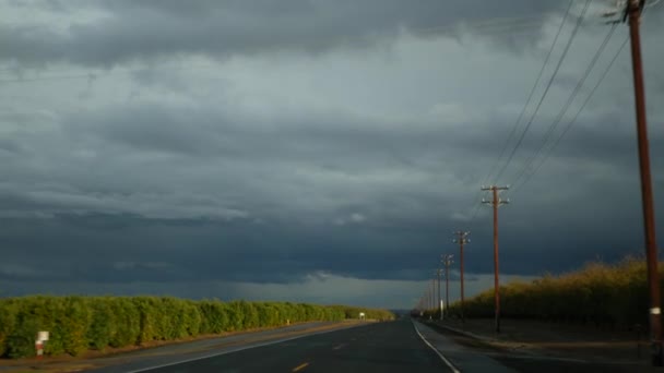 Samochodem, wycieczka w Kalifornii, USA, widok z samochodu. Autostopem podróżuje w Stanach Zjednoczonych. Autostrada, góry i zachmurzone, dramatyczne niebo przed deszczem. Amerykańska malownicza droga. POV dla pasażerów — Wideo stockowe