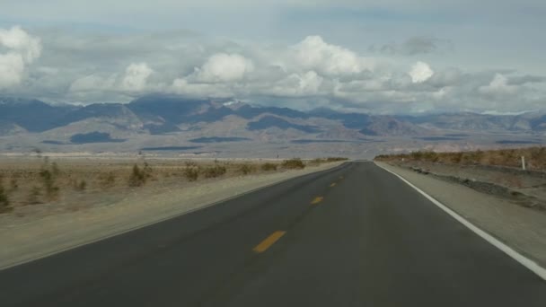 Viaje por carretera a Death Valley, conduciendo un auto en California, EE.UU. Hacer autostop viajando por América. Carretera, montañas y desierto seco, árido clima salvaje. Punto de vista del pasajero del coche. Viaje a Nevada — Vídeos de Stock