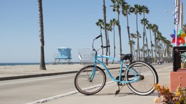 Ποδήλατο καταδρομικό ποδήλατο από την παραλία του ωκεανού, Καλιφόρνια ακτή ΗΠΑ. Καλοκαιρινός κύκλος, καλύβα ναυαγοσώστη και φοίνικας — Αρχείο Βίντεο