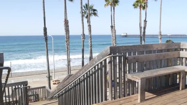 Вуденская лестница, выход на пляж в Калифорнии, США. Прибрежные лестницы, океанские волны и пальмы. — стоковое видео