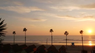 Palmiyeler ve günbatımı gökyüzü, California estetiği. Los Angeles havası. Cankurtaran Kulesi, kulenin kulübesini izleyin.