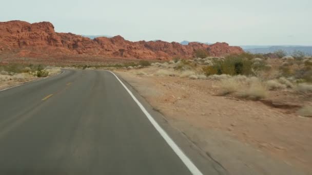 Roadtrip, Autofahren in Valley of Fire, Las Vegas, Nevada, USA. Per Anhalter in Amerika unterwegs, Autobahnfahrt. Rote außerirdische Felsformation, Wüste Mojave sieht aus wie Mars. Blick aus dem Auto — Stockvideo