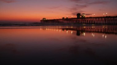 İskele silueti Oceanside California USA. Okyanus gelgiti tropik plaj. Yaz zamanı parlayan atmosfer.