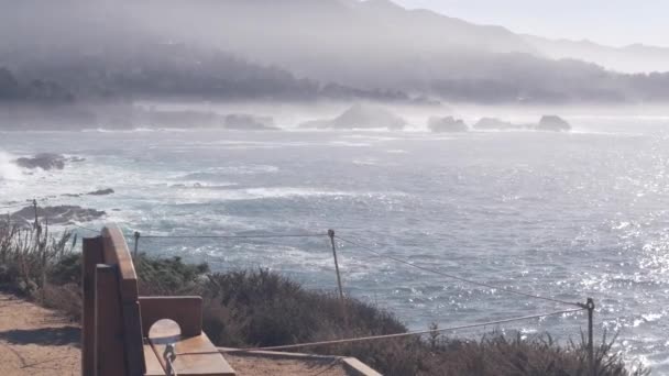Rocky craggy ocean beach, Point Lobos, California coast. Empty bench on trail. — Stock Video