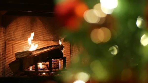 Christmas tree lights by fire in fireplace, New Years Eve or Xmas decoration. — Stock Photo, Image