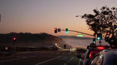 Trafik ışıkları, Pasifik kıyısı otoyolu, California. Alacakaranlıkta okyanus boyunca yolculuk