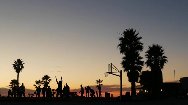 Spelare på basketplan spelar basket bollspel, solnedgång stranden, Kalifornien. — Stockfoto