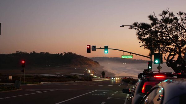Traffic lights, pacific coast highway, California. Road trip along ocean in dusk