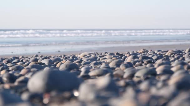 Skały żwirowe, piaszczysta plaża, morskie fale wodne, okrągłe kamienie gładkie lub głaz — Wideo stockowe
