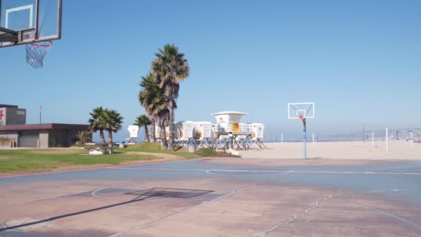 Palmeras y cancha deportiva de baloncesto en la playa, costa de California, EE.UU.. — Vídeo de stock